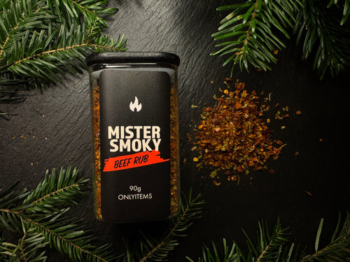 Mister Smoky Beef Rub container on a dark surface with greenery
